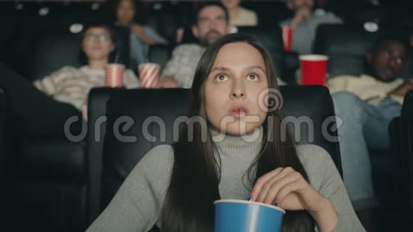 震惊的女士张开嘴拿着爆米花看电影视频的预览图