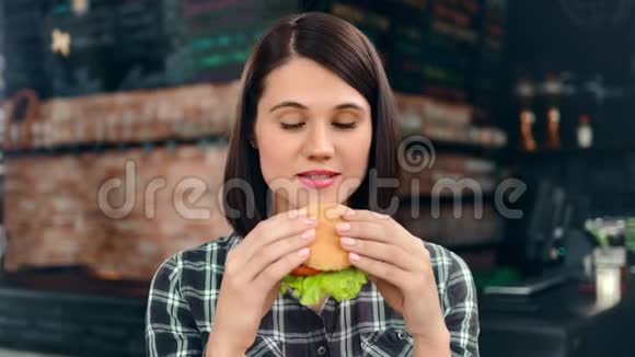 饥饿的少女微笑的女人吃快餐的肖像看着中的特写视频的预览图