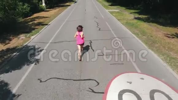 穿着短短裤穿过公园的年轻苗条女孩一位身材魁梧身材魁梧身材魁梧的女人正在城市公园里奔跑视频的预览图