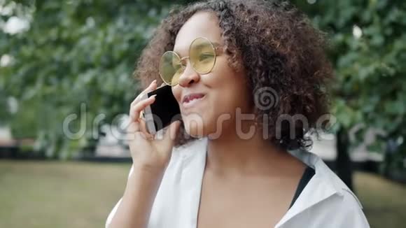 一位性格开朗的美国黑人女士在户外玩手机笑视频的预览图