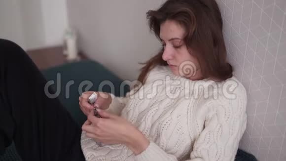 一位年轻的女士躺在卧室的床上为治疗流感和感冒提供了一个长时间的指导处方药视频的预览图