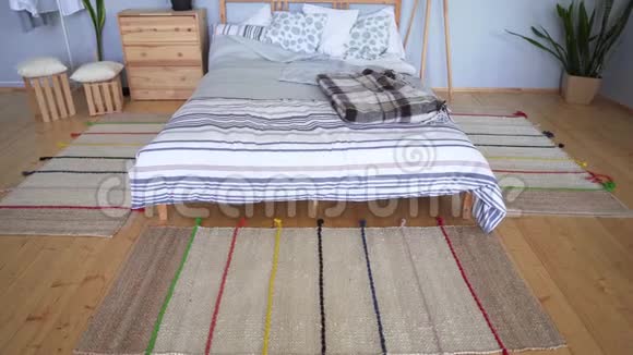 在斯堪的纳维亚风格的公寓里白人女孩在一张木床旁拉起针织粉色袜子视频的预览图
