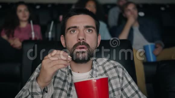 震惊的年轻人在电影院看电影张嘴扔爆米花视频的预览图