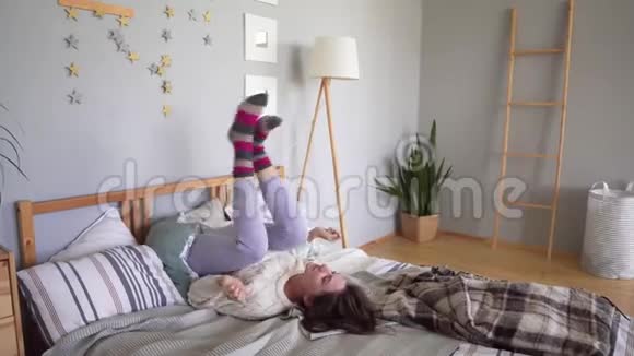 迷人的女人在床上玩得很开心到处胡闹扭着腿假装是司机视频的预览图
