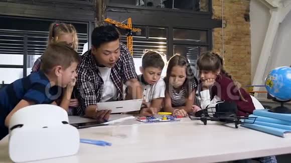 用平板电脑拍摄了六名白人学童观看他们的亚洲男教师的照片视频的预览图