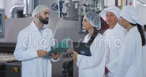 烘焙行业工人小组工程师解释工业机器的安全计划老面包师和他的视频的预览图