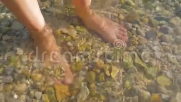 人脚站立在非常清澈的海洋水海水男人的腿上覆盖着水和可见的屁股游客腿视频的预览图