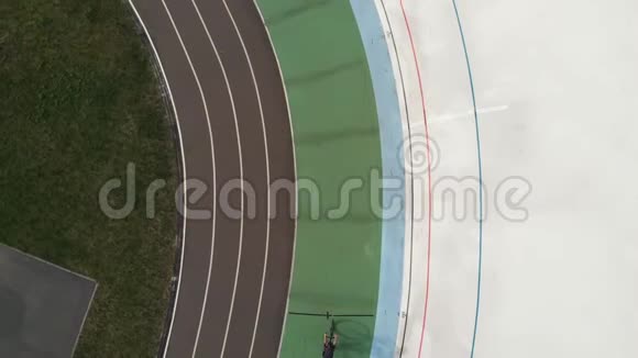 在velodrome进行道路自行车训练的女性自行车运动员的无人机顶视图年轻的骑自行车女孩骑着自行车在维洛德慢慢地视频的预览图