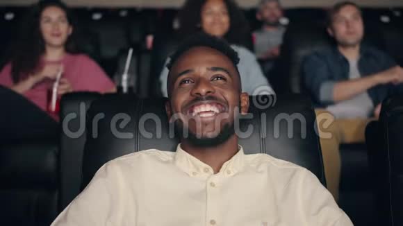 在电影院欣赏电影的美国黑人慢镜头笑着视频的预览图