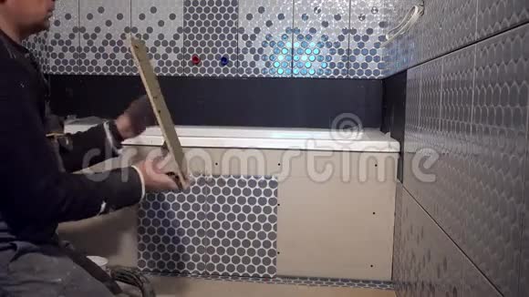 熟练工人在浴室的浴缸边铺瓷砖视频的预览图