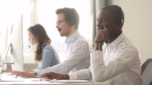 非洲男性呼叫中心工作人员戴耳机远程帮助客户视频的预览图