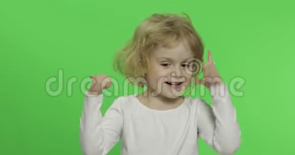 穿白色t恤的快乐金发小女孩可爱的金发孩子上面的东西视频的预览图