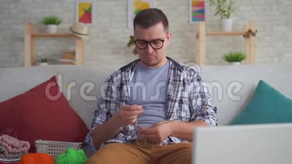 把手中有辐条的年轻人用笔记本电脑在训练视频上编织起来视频的预览图