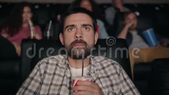 恐怖的家伙在电影院看惊悚电影手里拿着饮料恐惧地尖叫视频的预览图