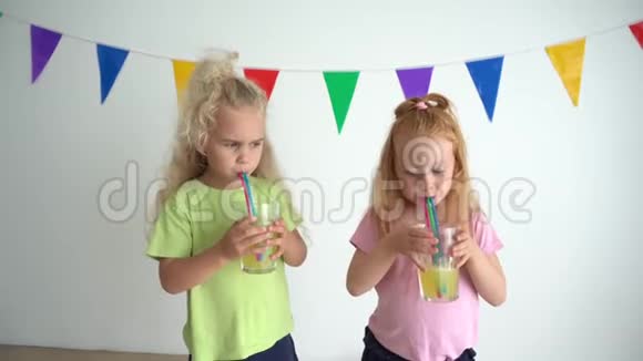 淘气的女孩用吸管在橙汁杯里泡泡泡视频的预览图