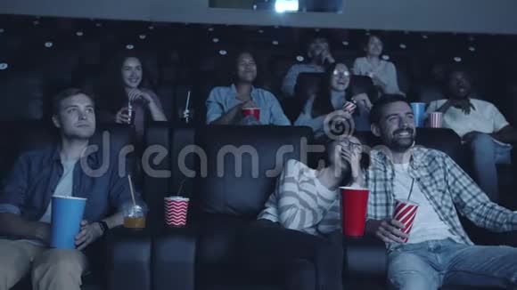 欢快的千禧一代在现代电影院看电影时的慢动作视频的预览图