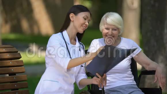 微笑女医生给坐轮椅的快乐老年妇女做脊柱x光检查视频的预览图