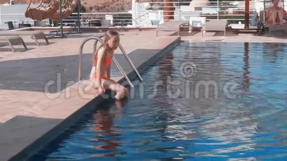 可爱的快乐少女在室外游泳池游泳视频的预览图