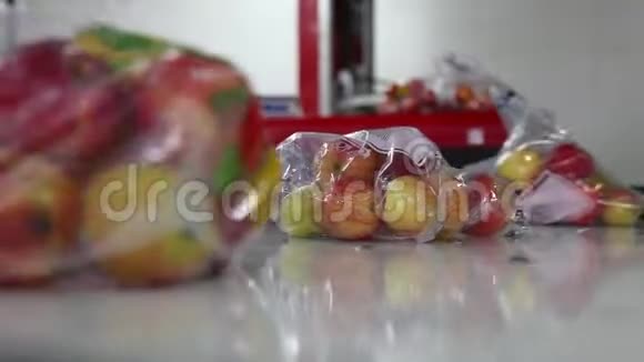 装在塑料袋里的苹果沿着传送带移动视频的预览图