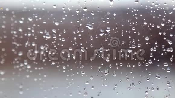 雨滴在蓝色玻璃背景上雨后滴在玻璃上视频的预览图