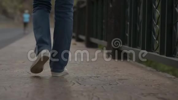 从亚洲女人的后侧看晚上穿着牛仔裤悠闲地走在沿路的小径上视频的预览图