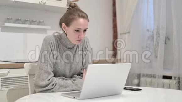 年轻女性在家中思考和工作笔记本电脑视频的预览图