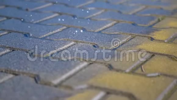 雨中潮湿的人行道雨滴落在人行道上视频的预览图