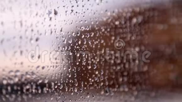 雨滴在蓝色玻璃背景上雨后滴在玻璃上视频的预览图