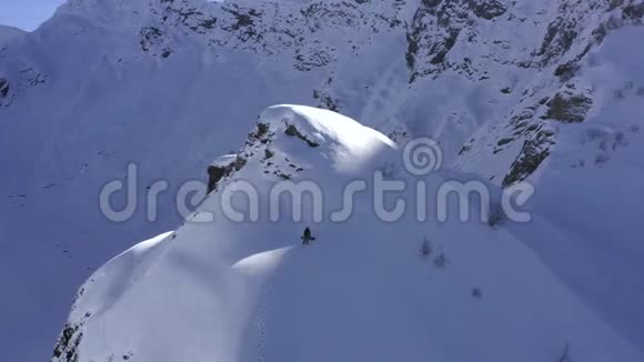 滑雪板和滑雪板在雪山上行走到达无人驾驶人峰的视野视频的预览图