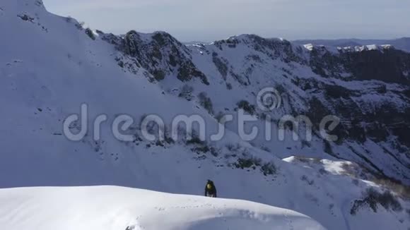 滑雪板与滑雪板攀登雪峰冬季山地无人机视野视频的预览图