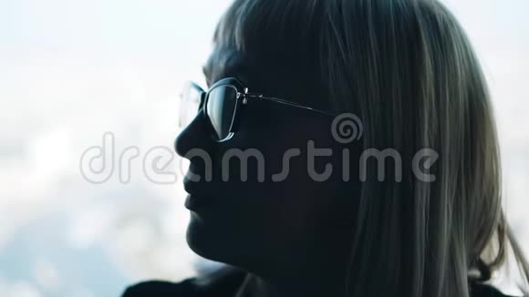 那女孩的沉思神情在明亮的窗户背景上戴眼镜的女孩视频的预览图
