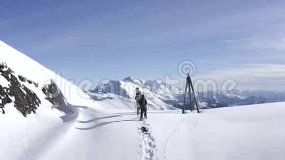 提供设备和雪鞋的滑雪板徒步旅行的雪山无人机近景视频的预览图