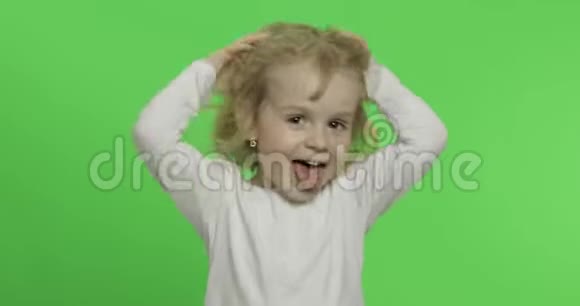 穿白色t恤的快乐金发小女孩可爱的金发孩子做鬼脸视频的预览图