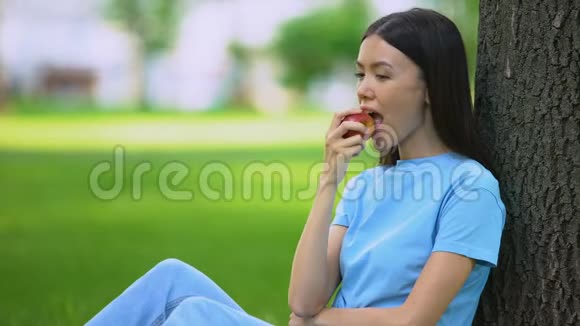 亚洲漂亮的女性在户外吃新鲜苹果健康的零食维生素视频的预览图