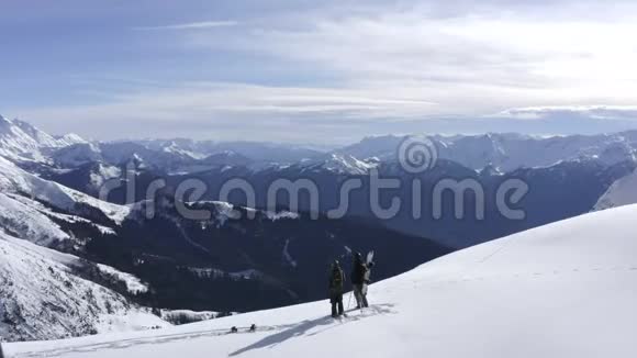 站在冬山雪峰上的滑雪板上视频的预览图