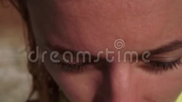 一个美丽的女孩额头头发眉毛蓝色的眼睛在明亮的阳光下特写视频的预览图