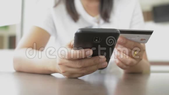 女性在家用信用卡在线购物网上银行用智能手机使用智能手机轻松支付视频的预览图