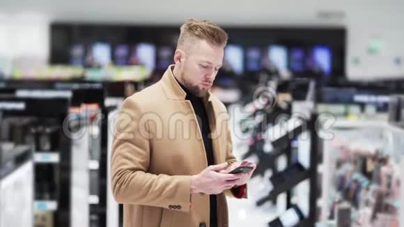穿着棕色外套的年轻人在化妆品商店用电话拍照视频的预览图