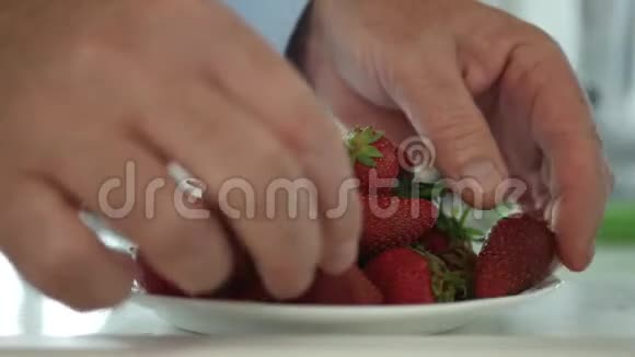 厨房活动与男人选择和清洁草莓水果的盘子视频的预览图