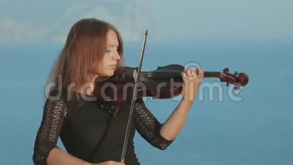 一位漂亮的小提琴手穿着巫术服装演奏着视频的预览图