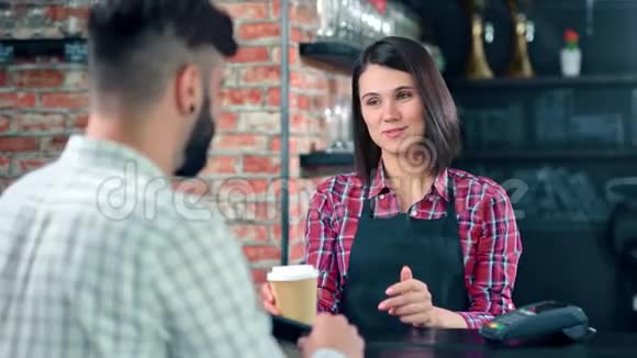 微笑的女咖啡师在阁楼咖啡厅为男顾客制作清新的咖啡纸杯视频的预览图