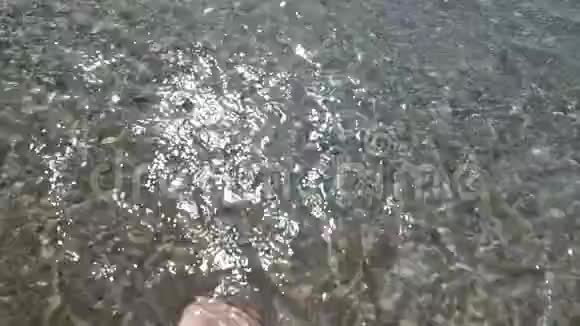 海水冲刷着晒黑的雌性脚视频的预览图