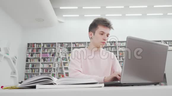 图书馆用笔记本电脑拍摄的男生低角度镜头视频的预览图