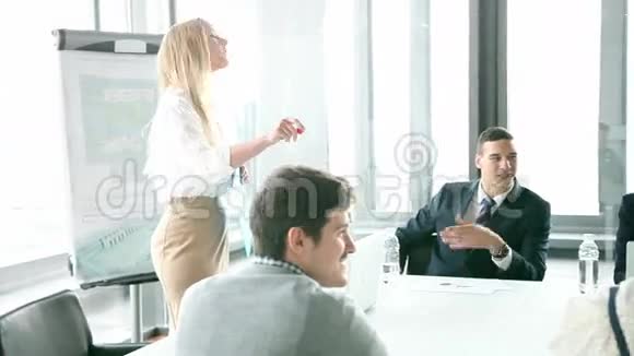 商务人士坐在餐桌旁而女性同事则在做演讲视频的预览图