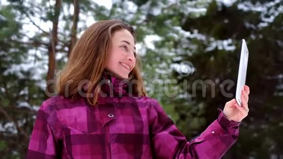 冬天森林里有ipad的女人视频的预览图