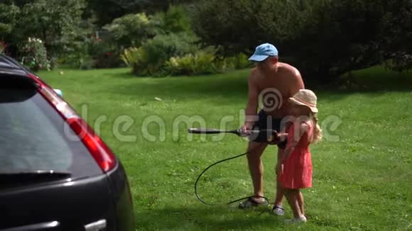 爸爸和快乐的小女孩在户外洗车有女儿的男人视频的预览图