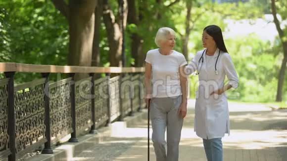 医生在公园散步与老年女性病人甘蔗康复视频的预览图