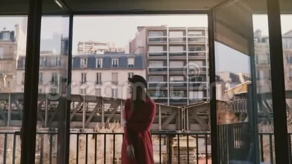 镜头对准年轻快乐的白种人女游客她微笑着在阳光明媚的巴黎阳台上欣赏埃菲尔铁塔的慢镜头视频的预览图
