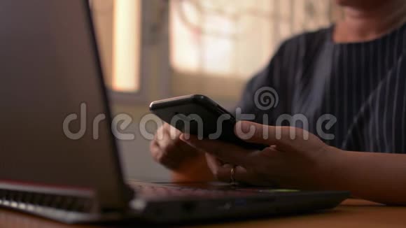 在工作桌上用移动智能手机关闭女性的双手以便在线社交视频的预览图