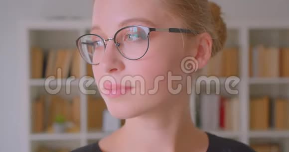 年轻貌美的白种人女学生戴着眼镜转过身来看着镜头开心地笑着视频的预览图